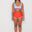 Woman wearing a light blue sports and swim bra and red swim shorts on a white background