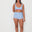 Woman wearing a light blue bralette surf top and high-waisted original betty bottom shorts on a white background