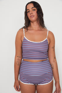 Woman wearing a merlot striped swimsuit, tankini surf top and betty bottoms 2.0 against a white background, free people and salt gypsy