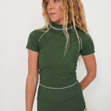 Woman wearing a green olive low rider rashguard and betty bottoms 2.0 with white trim on a plain background