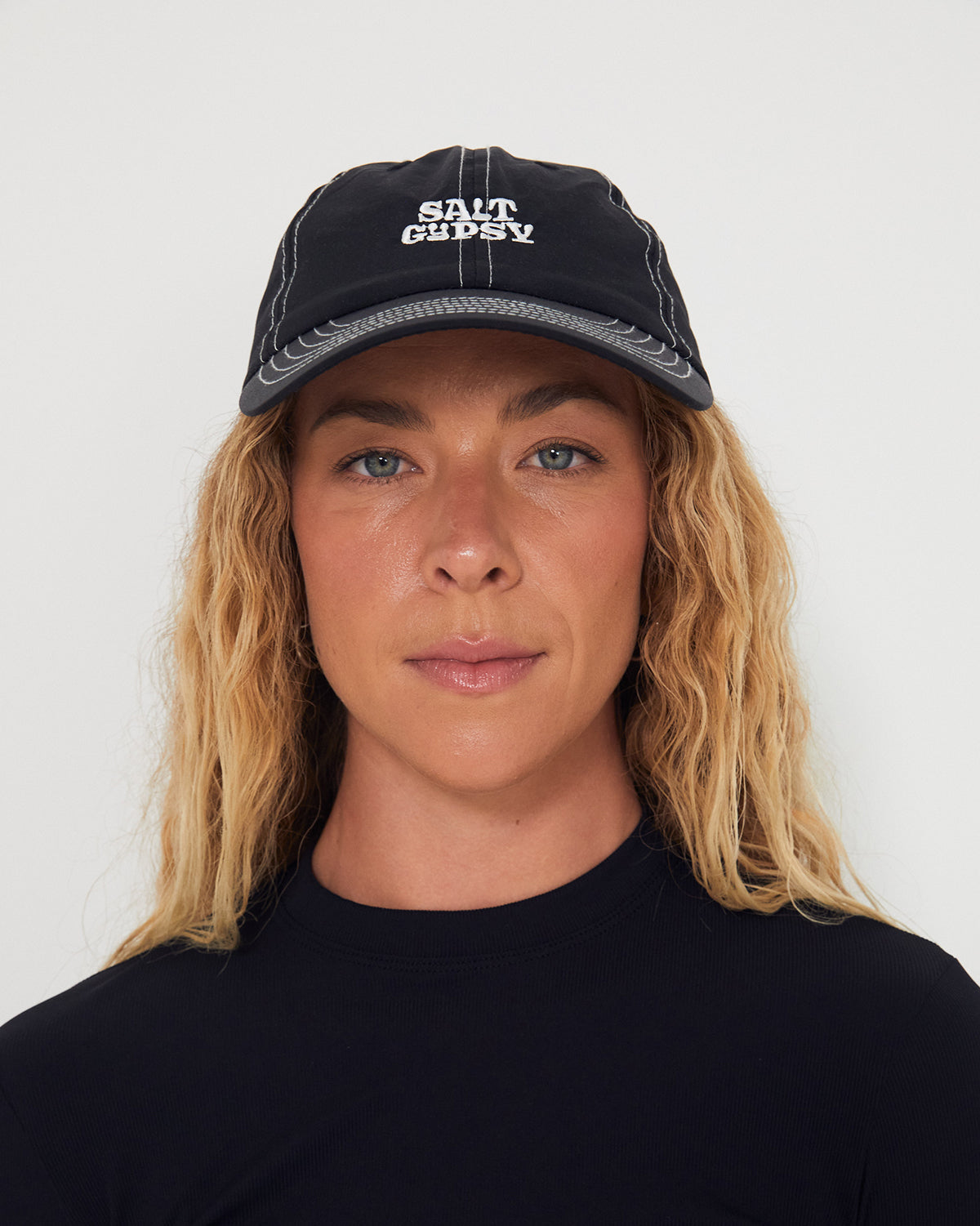 Person wearing a black dad nylon cap with 'Salt Gyspy' logo against a white background